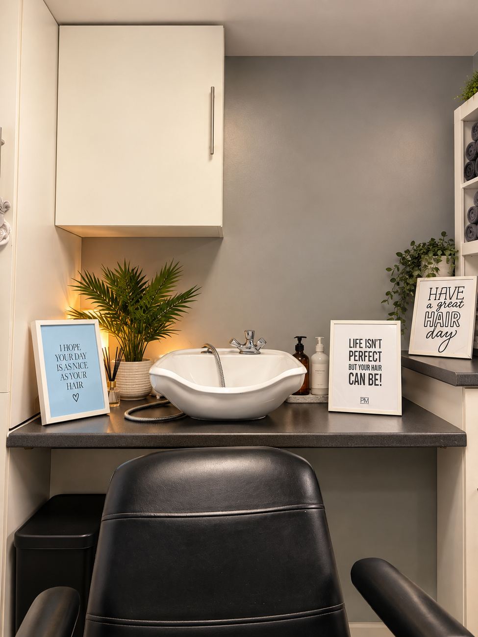 The hairdressing corner at Higher Park Lodge, with a basin, a salon chair and a sign that reads Have a great hair day.